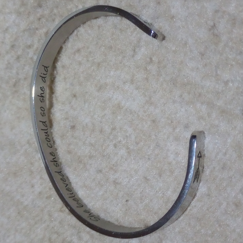 Silvertone bangle with "She believed she could so she did." Engraved inside